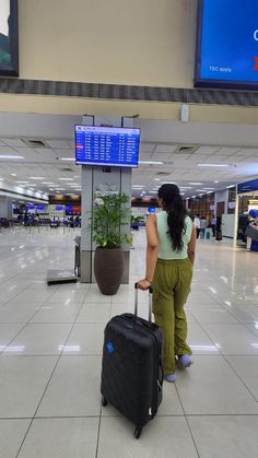 a woman pulling a suitcase through an airport