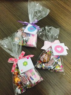 three bags filled with candy on top of a wooden table