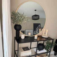 a black table with a mirror and candles on it