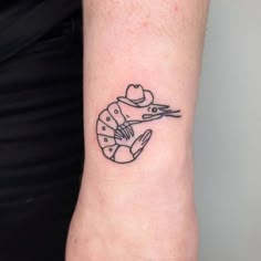 a woman's arm with a small tattoo of a bird and a cowboy hat on it