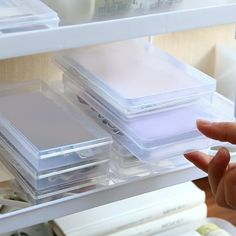 a person is holding some plastic containers in their hand and looking at the contents on the shelf