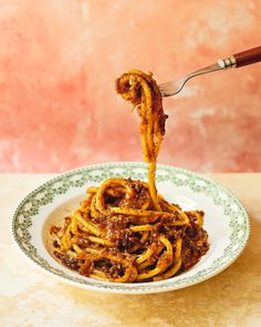 spaghetti being eaten with a fork in a bowl