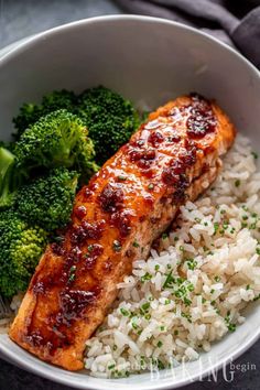 a bowl filled with rice, broccoli and salmon on top of each other