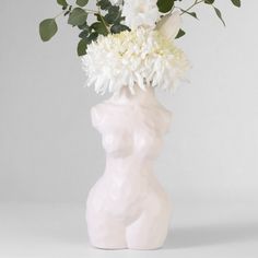 a white vase filled with flowers on top of a table