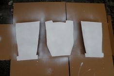 three pieces of white paper sitting on top of cardboard