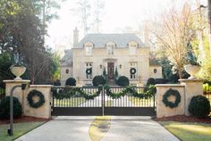 a large white house with wreaths on the front gate