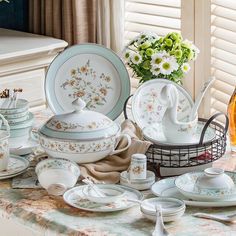 a table topped with lots of dishes and cups