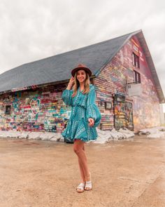 a woman standing in front of a colorful building