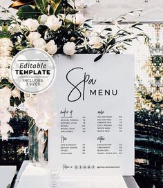 a menu with white flowers and greenery is displayed in front of an outdoor venue