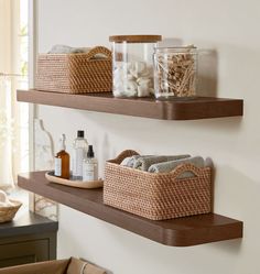 two wooden shelves with baskets and bottles on them