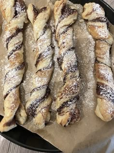 several pastries sitting on top of a pan covered in powdered sugar