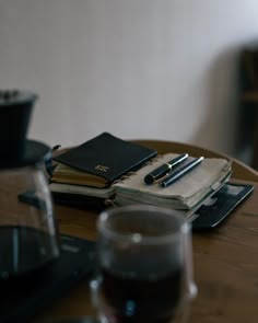 a wooden table topped with notebooks and glasses