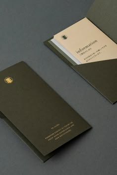 two business cards on top of each other, one with a gold and white logo