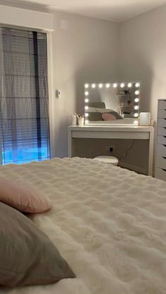 a bedroom with a bed, dresser and dressing table in it's center area