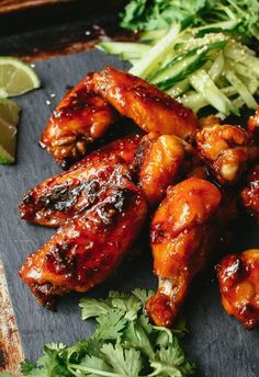 chicken wings with sauce and cilantro on a cutting board