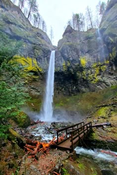 a waterfall with a wooden bridge over it