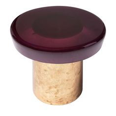 a close up of a purple and gold knob on a white surface with a black top