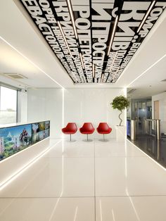 an office lobby with red chairs and white walls