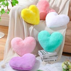 three heart shaped pillows sitting on top of a white blanket next to a box of tissues