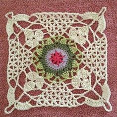 a crocheted square with a flower in the center on a red background,