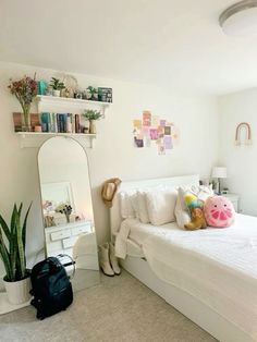 a bedroom with a bed, mirror and stuffed animal on the floor in front of it