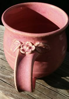 a pink vase sitting on top of a wooden table