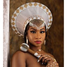 a woman wearing a white and gold headpiece with her hands on her chest, posing for the camera