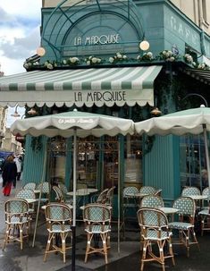 an outdoor cafe with tables and umbrellas on the side walk in paris, france