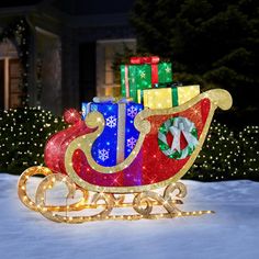 a sleigh with presents on it in front of a christmas tree and lights