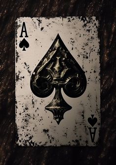 an ace playing card on top of a wooden table with black and white ink splatters