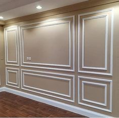 an empty room with wood floors and white paneling