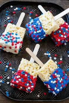 fourth of july rice krispy treats on a black plate with red, white and blue sprinkles