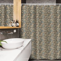 a bathroom with a sink, mirror and shower curtain that has a flower pattern on it