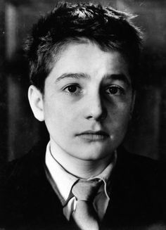 black and white photograph of a young man wearing a suit with a tie on his neck