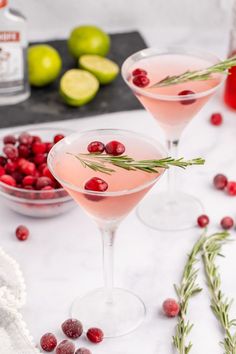 cranberry martini with rosemary garnish in coupe glasses