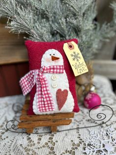 a snowman pillow sitting on top of a wooden sled