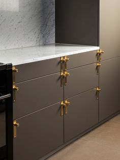 a kitchen with marble counter tops and gold handles