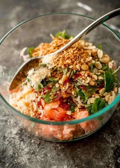 a glass bowl filled with lots of food and a spoon sticking out of the top