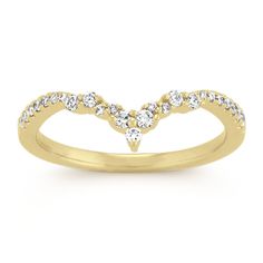 a yellow gold wedding band with white diamonds in the shape of a v, on a white background