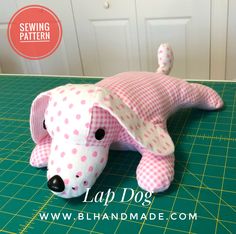 a pink and white dog stuffed animal laying on a green cutting board with the words sewing pattern below it