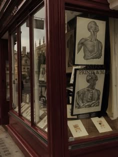 an old fashion store window with drawings on display