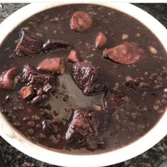 a bowl filled with meat and beans on top of a table