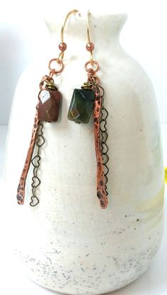 These long copper earrings are made from several materials.  They have a 2" solid copper, hammered bar with a dainty bronze, heart chain hanging beside it. The 1cm rectangle stones are faceted and different colors.  These are Jasper-One green, one reddish brown These are 3" long, lightweight with handcrafted brass French ear wires. We have these and many other handcrafted jewelry items in our store. Please look around for a unique gift idea If you need any further information, please contact me. Thanks for looking Rustic Handmade Metal Jewelry, Rustic Drop Earrings Jewelry For Gift, Rustic Drop Earrings Jewelry Gift, Rustic Drop Earrings As A Gift, Rustic Dangle Earrings As A Gift, Rustic Dangle Earrings For Gift, Rustic Green Dangle Jewelry, Rustic Nickel-free Dangle Jewelry, Green Rustic Dangle Jewelry