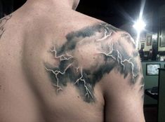 a man's back with lightning tattoo on it