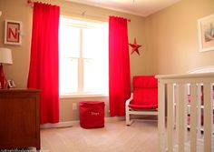 a baby's room with red curtains and white crib