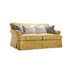 a yellow couch with pillows on it and two white pillows in the back, sitting next to each other