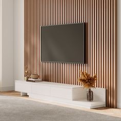 an entertainment center with a flat screen tv mounted on it's side, in front of a striped wall