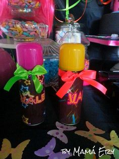 three bottles with candy and candies in them sitting on a black tablecloth covered table