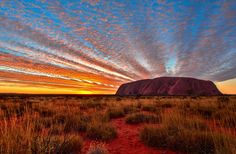 the sun is setting over aye rock in australia