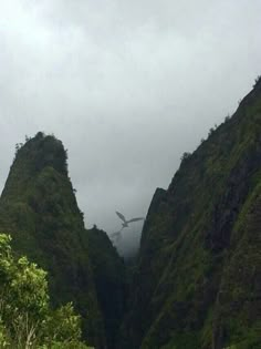 an airplane is flying over the mountains on a cloudy day